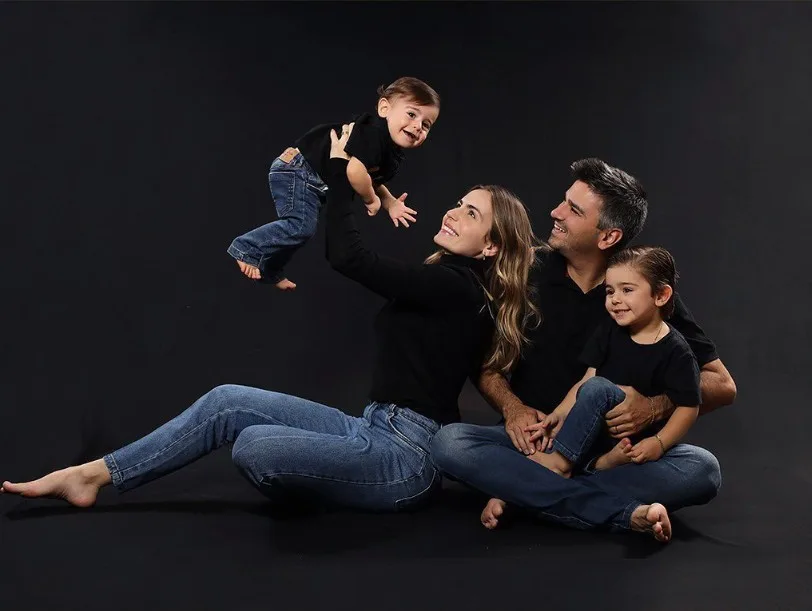 Família moderna posando com fundo preto