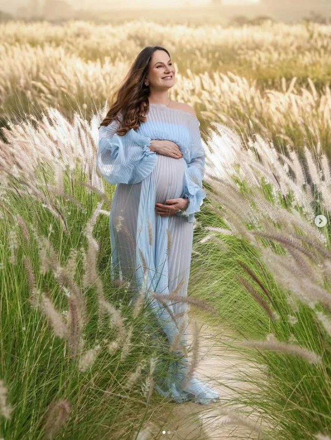 Ensaio gestante em vestido azul nas plumas douradas ao pôr do sol